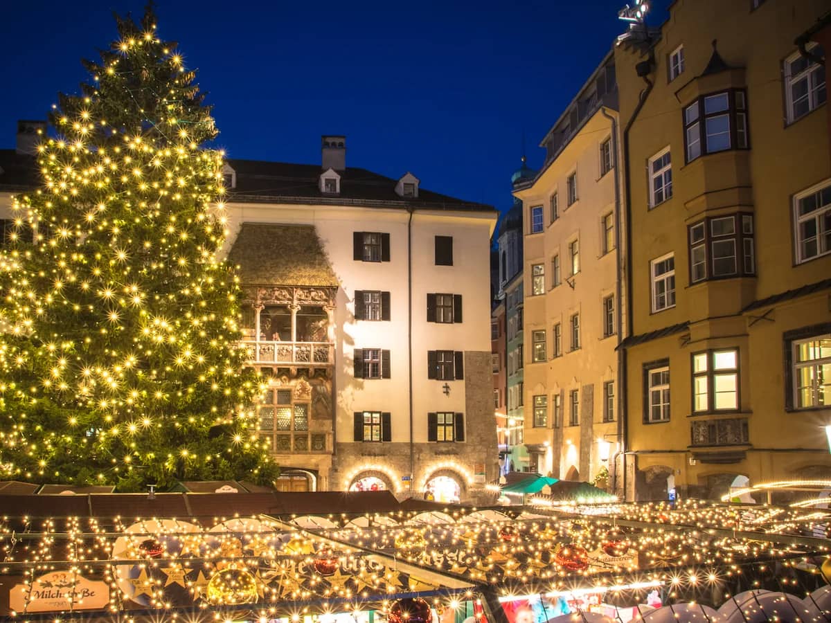 Innsbruck Christmas market with illuminated tree and historic architecture at blue hour