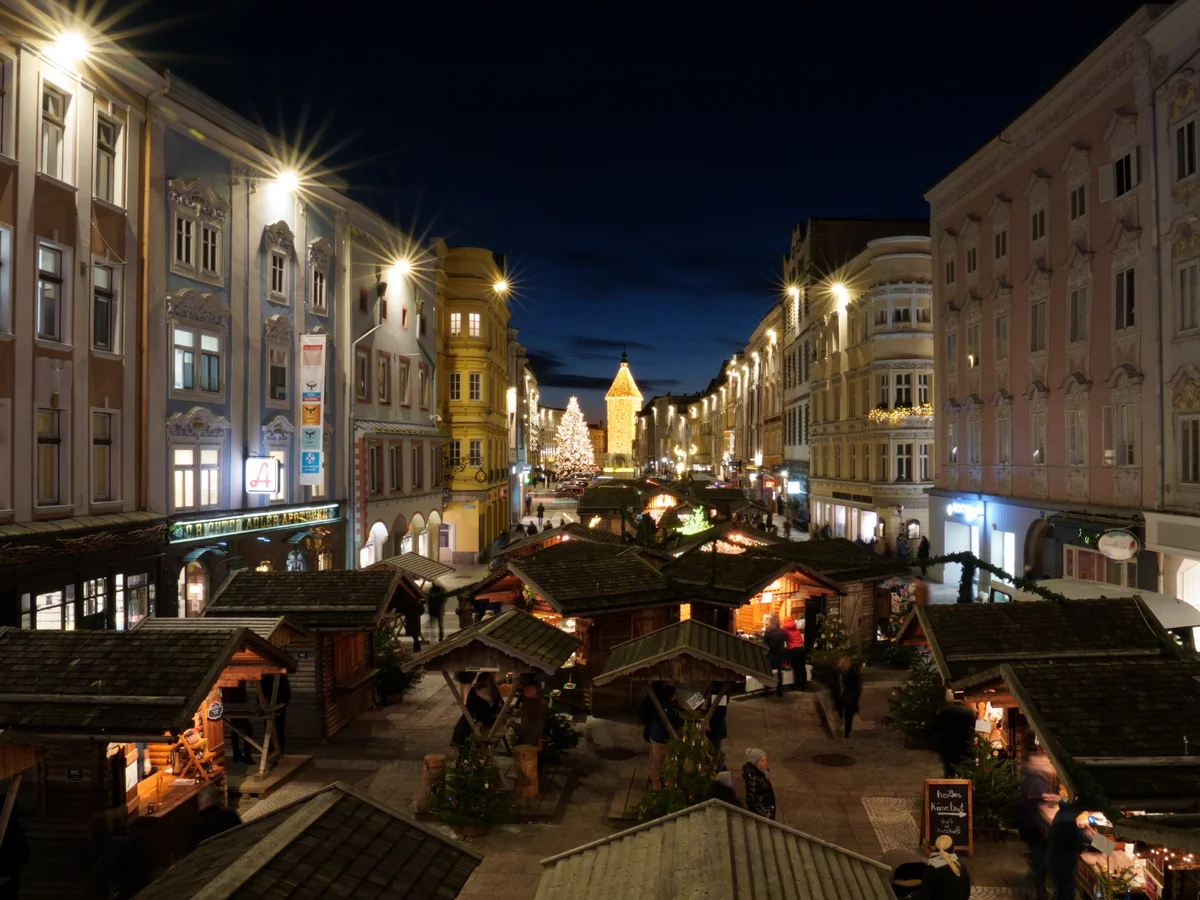 Adventdorf am Stadtplatz stunning blue hour in Steyr Christmas market with Gothic spire.