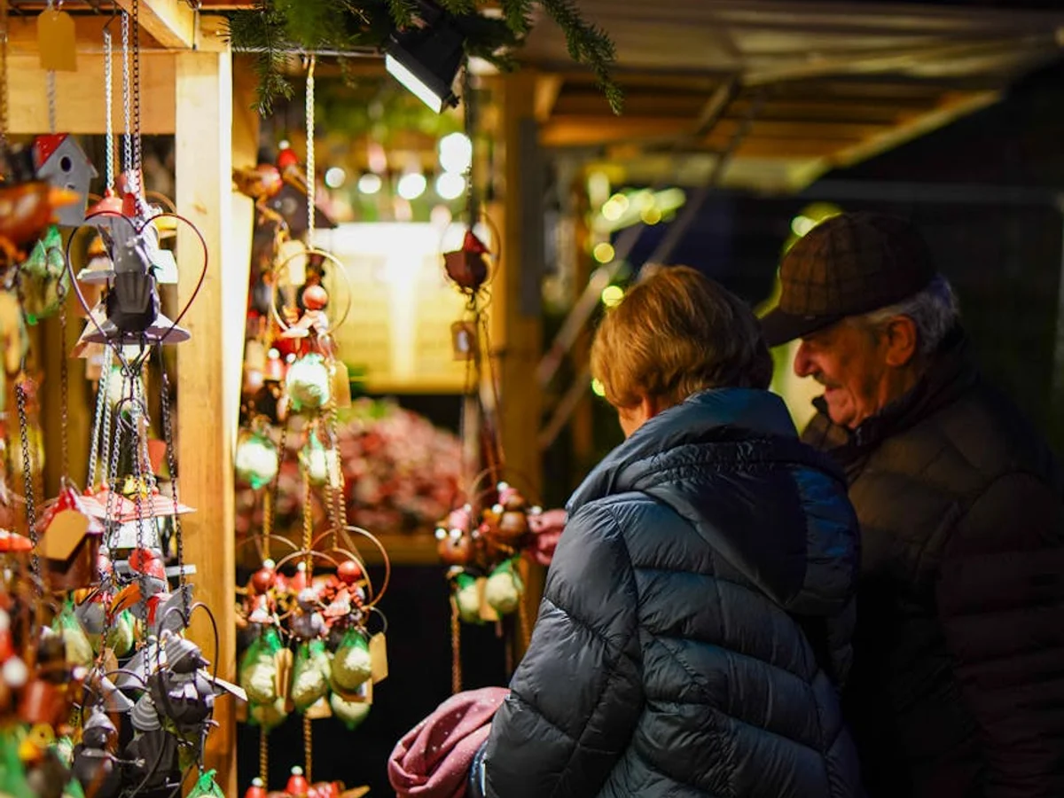 Karlovy Vary couple admiring ornaments at a Christmas market during winter evening