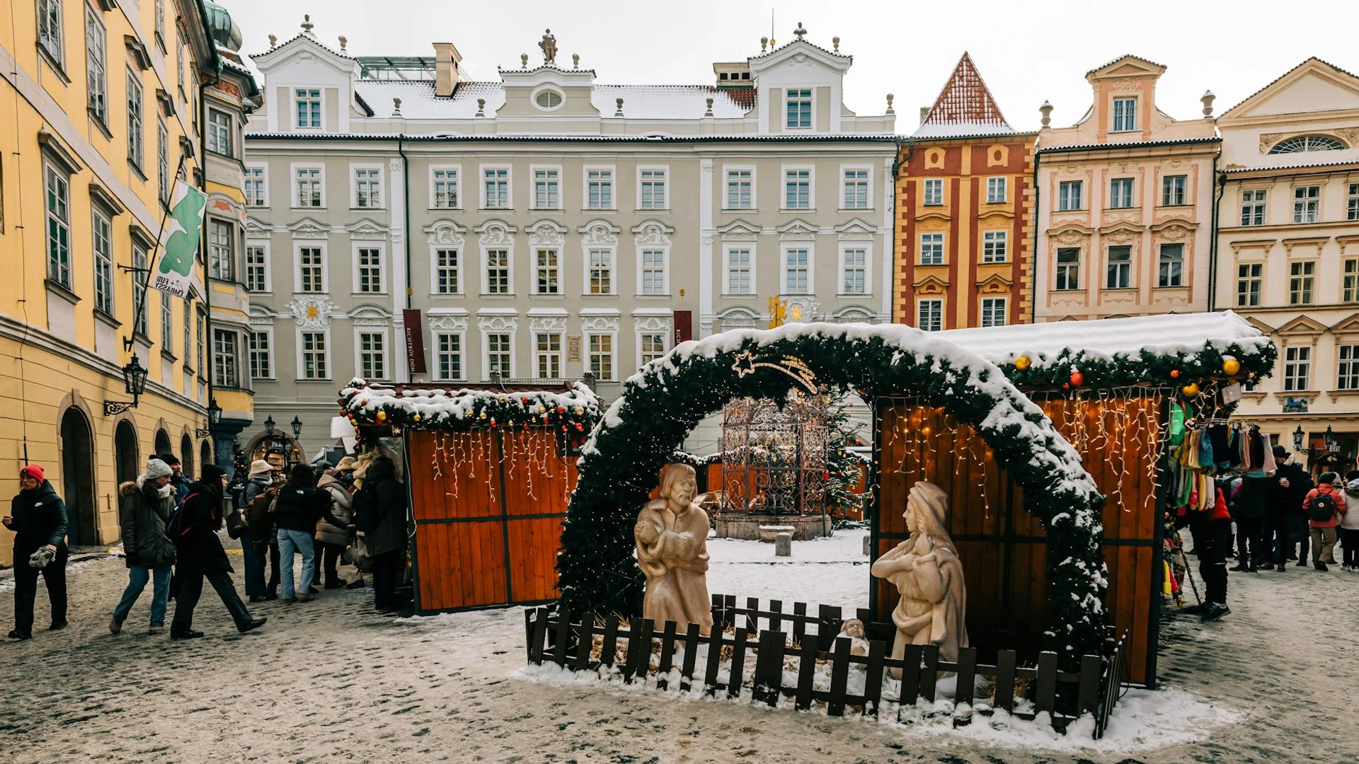 Prague Old Town Square adorned with festive Christmas market stalls in winter.