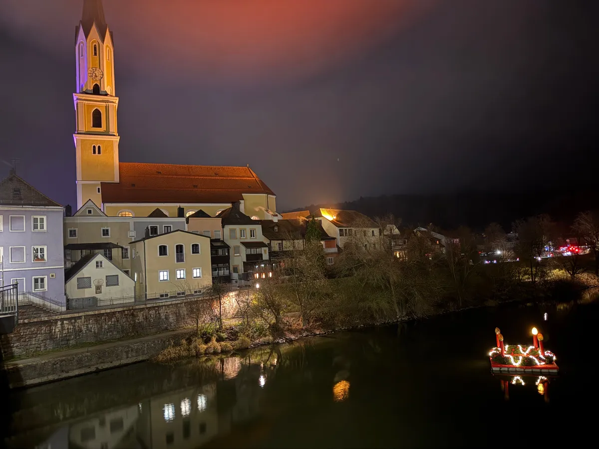 Unknown festive decorations and lights at a Christmas market in a charming riverside village.