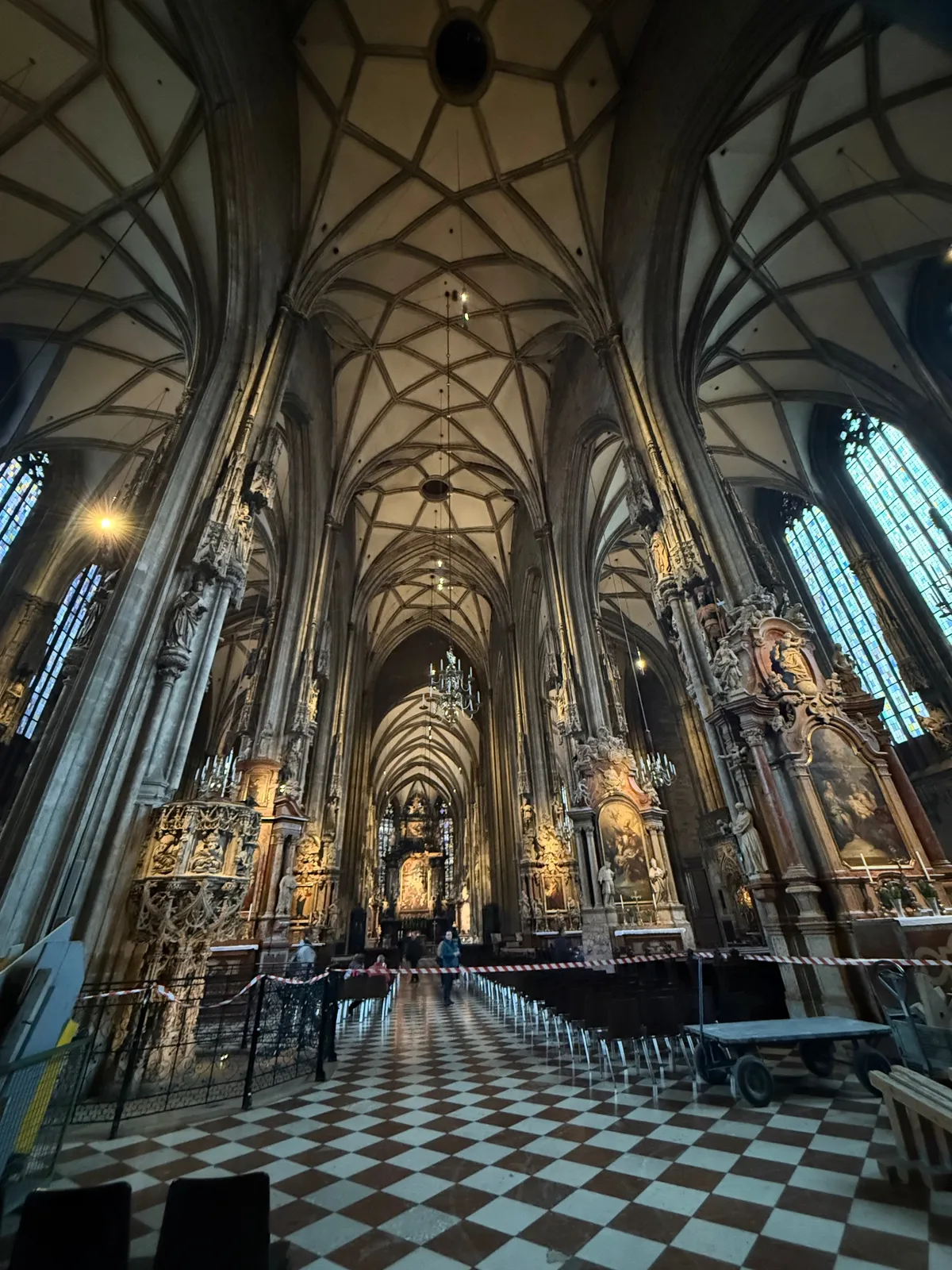 Stunning Gothic cathedral interior with festive decorations and lights reminiscent of an unknown Christmas market.