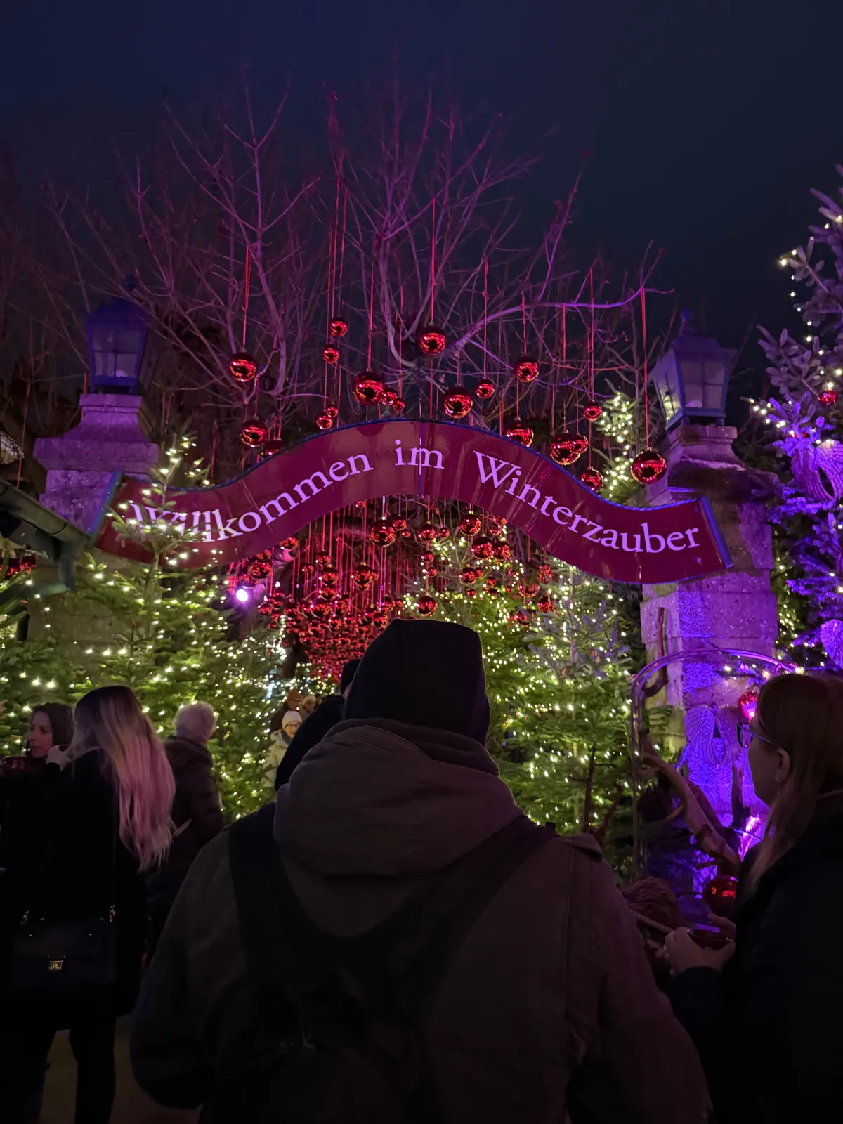 Unknown Christmas market entrance decorated with festive lights and heart-shaped ornaments.