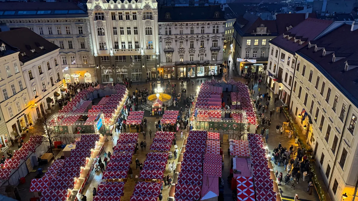Enchanting aerial view of an Unknown Christmas market with festive decorations and lights under a blue hour sky.