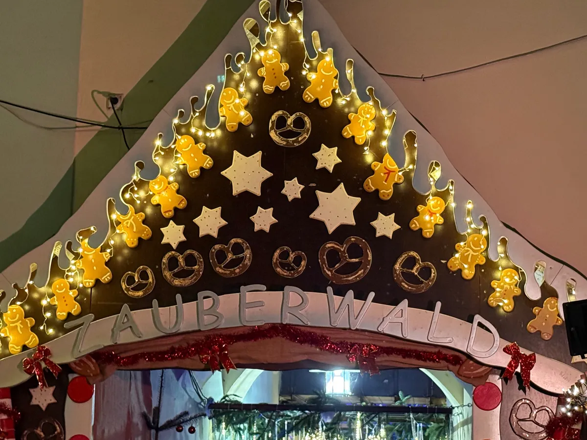Festive decorations and lights at an Unknown Christmas market featuring gingerbread figures and a cozy atmosphere.