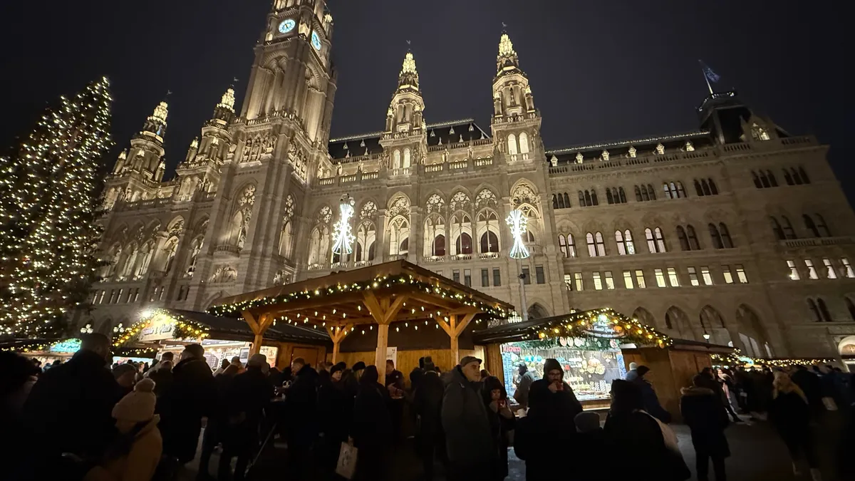 Gothic city hall illuminated at night with festive decorations and lights at an Unknown Christmas market.
