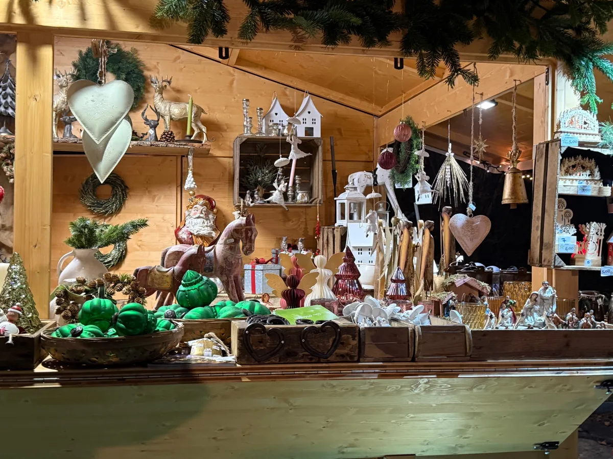 Charming Unknown Christmas market stall with festive decorations, lights, and handcrafted ornaments.