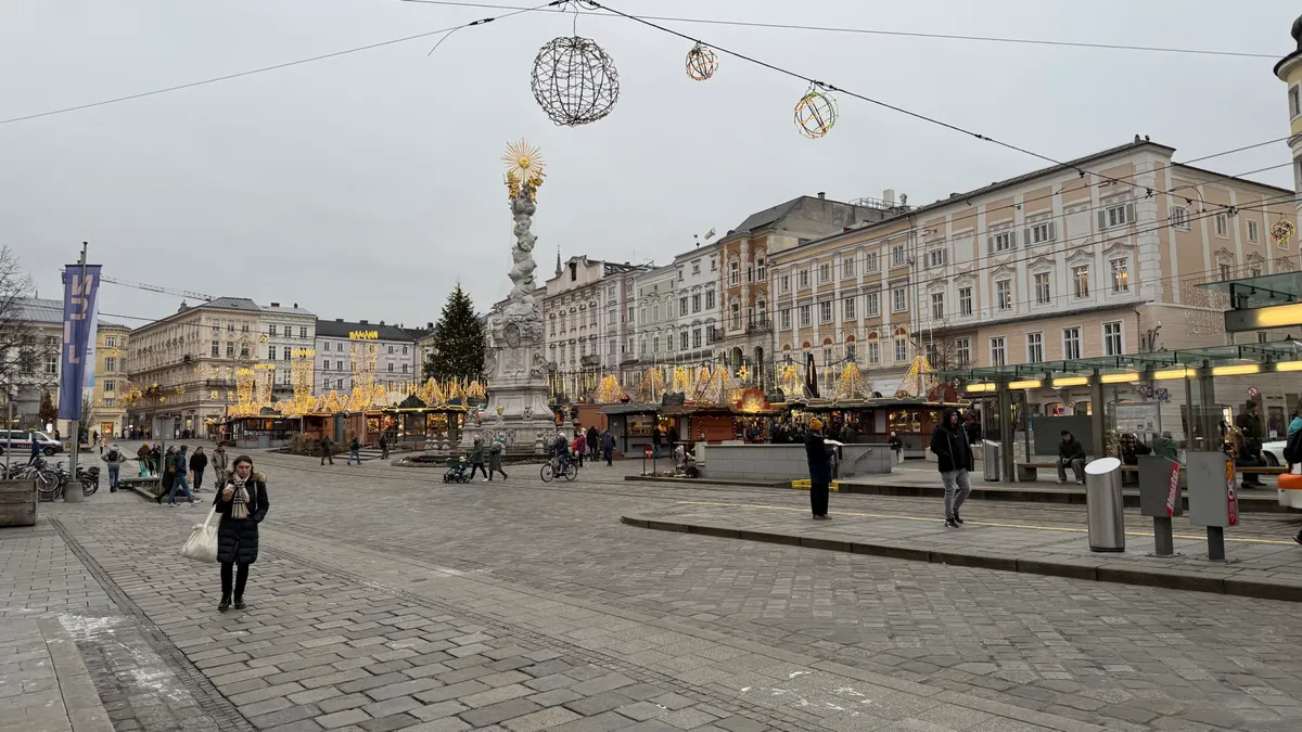 Festive decorations and lights at an Unknown Christmas market in Linz, showcasing golden elements and vibrant stalls.
