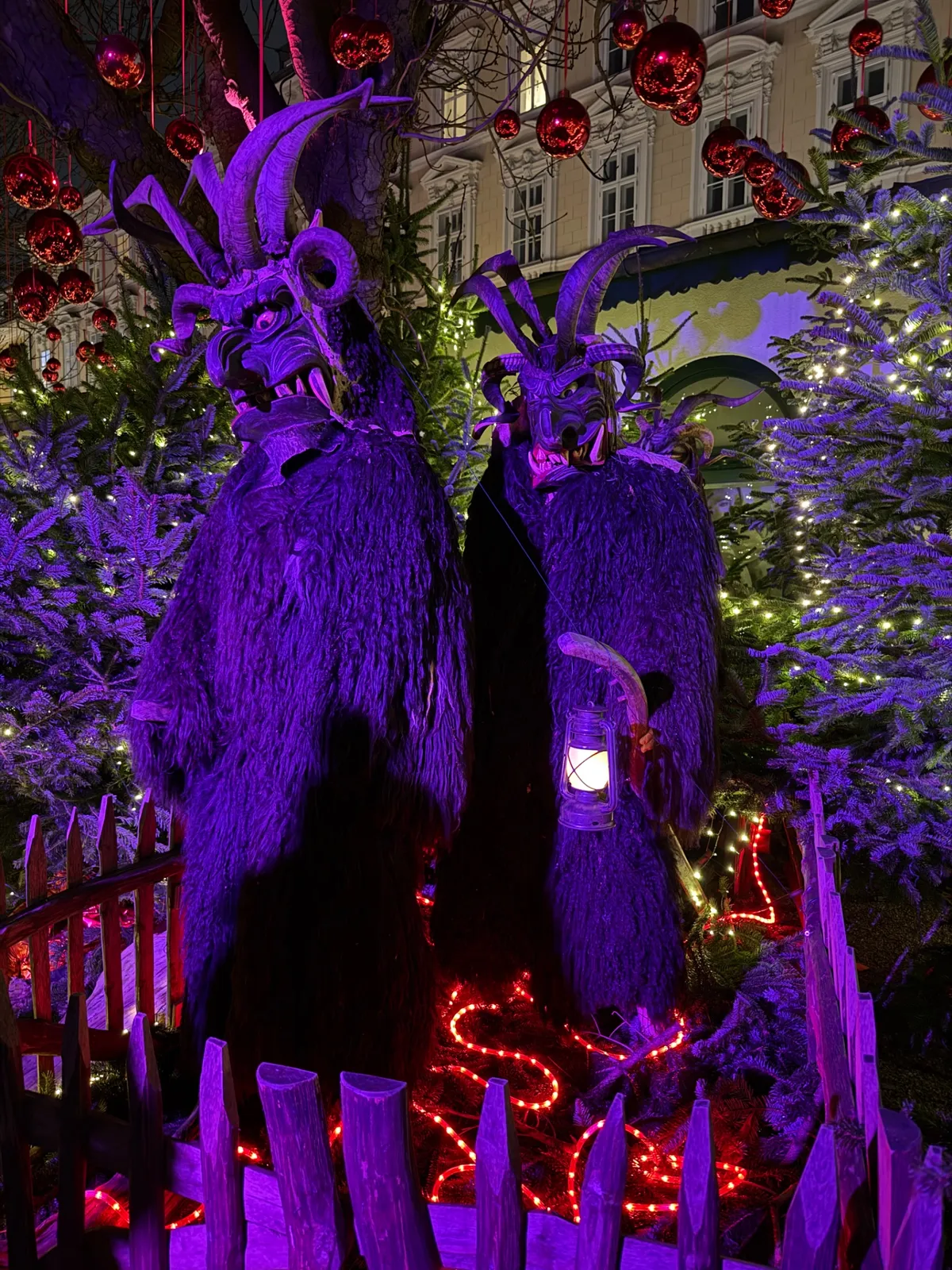Festive decorations and vibrant lights at an Unknown Christmas market with dramatic purple and red hues.