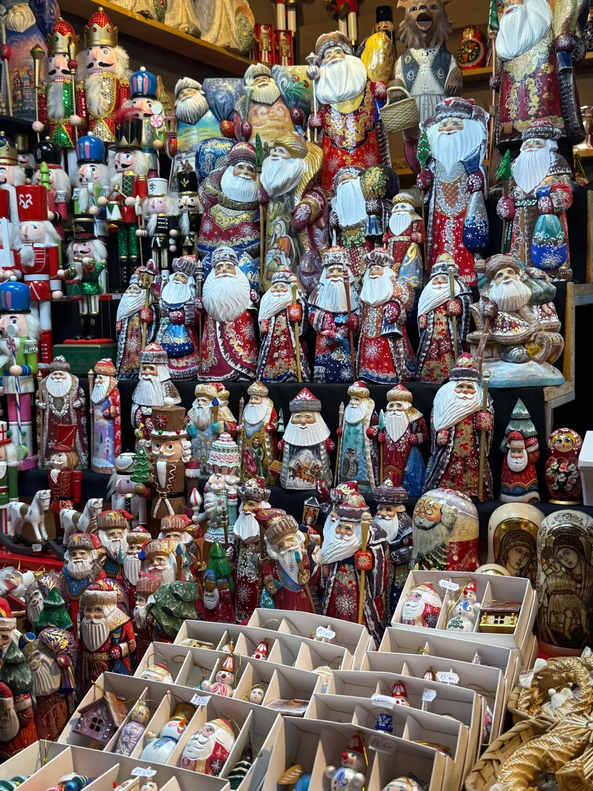 Colorful festive decorations at an Unknown Christmas market with vibrant nesting dolls and Santa figures.