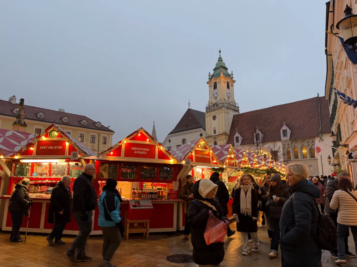 Festive decorations and warm lights at an Unknown Christmas market with red wooden stalls.