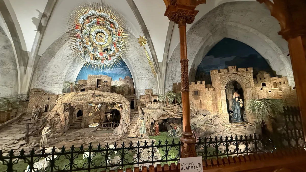 Ornate indoor diorama with festive decorations and lights, evoking an unknown Christmas market atmosphere.