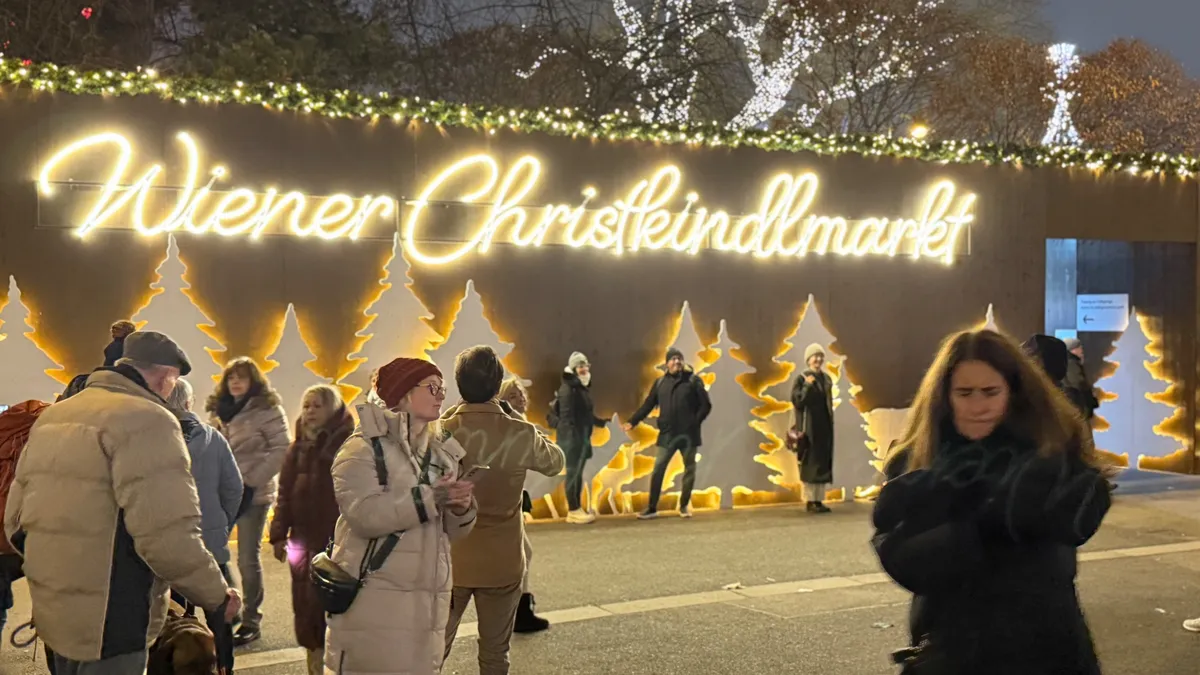 Unknown Christmas market with festive decorations, lights, and lively atmosphere in Vienna's Wiener Christkindlmarkt.