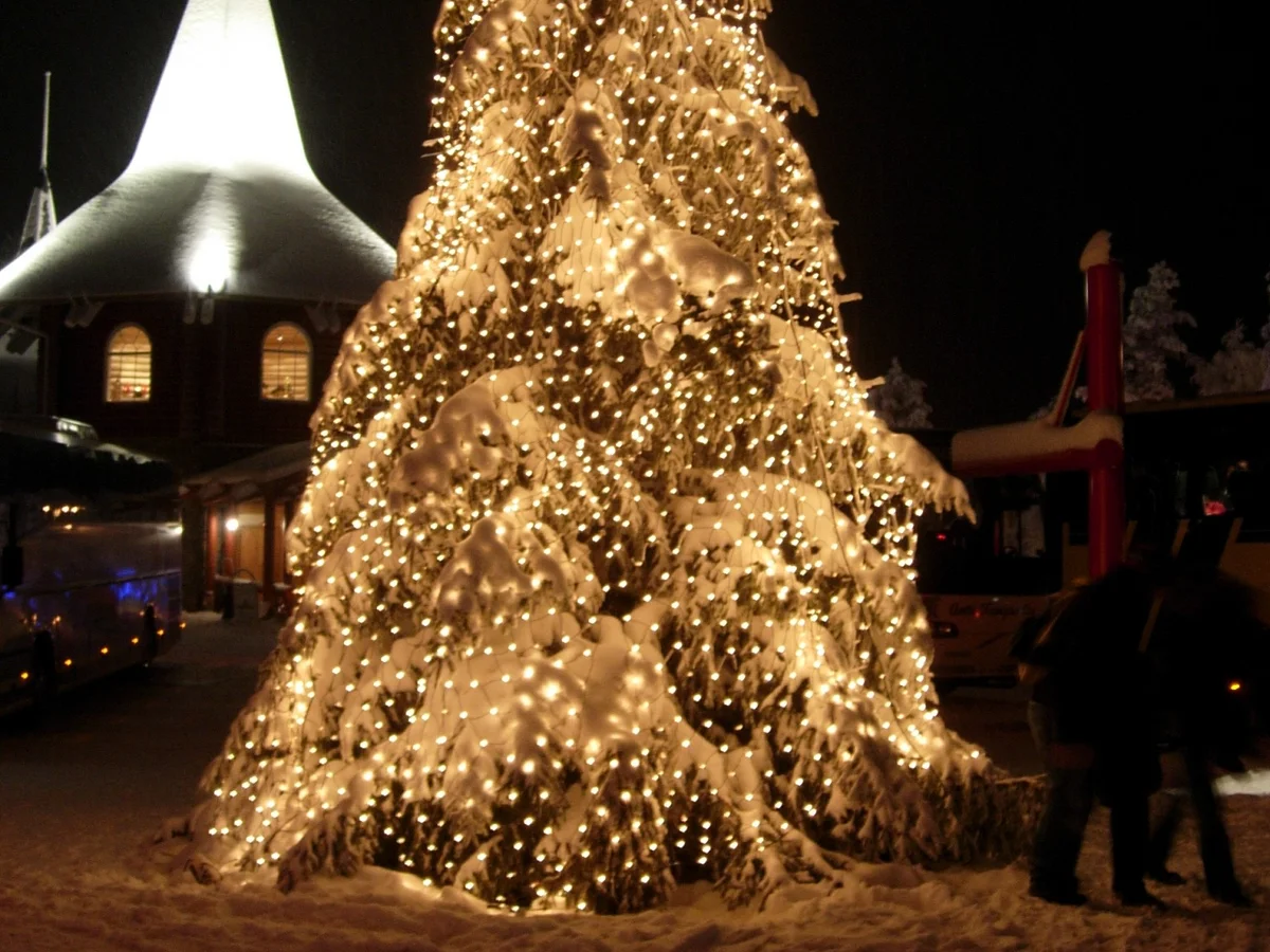 Rovaniemi illuminated Christmas tree next to Santa Claus Park's white chapel in winter