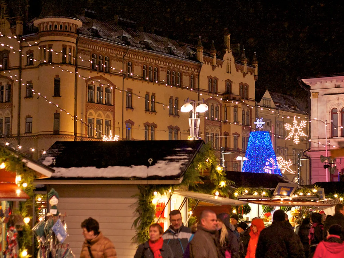 Joulutori's enchanting blue hour at Central Square, Tampere, with festive stalls and Art Nouveau City Hall.
