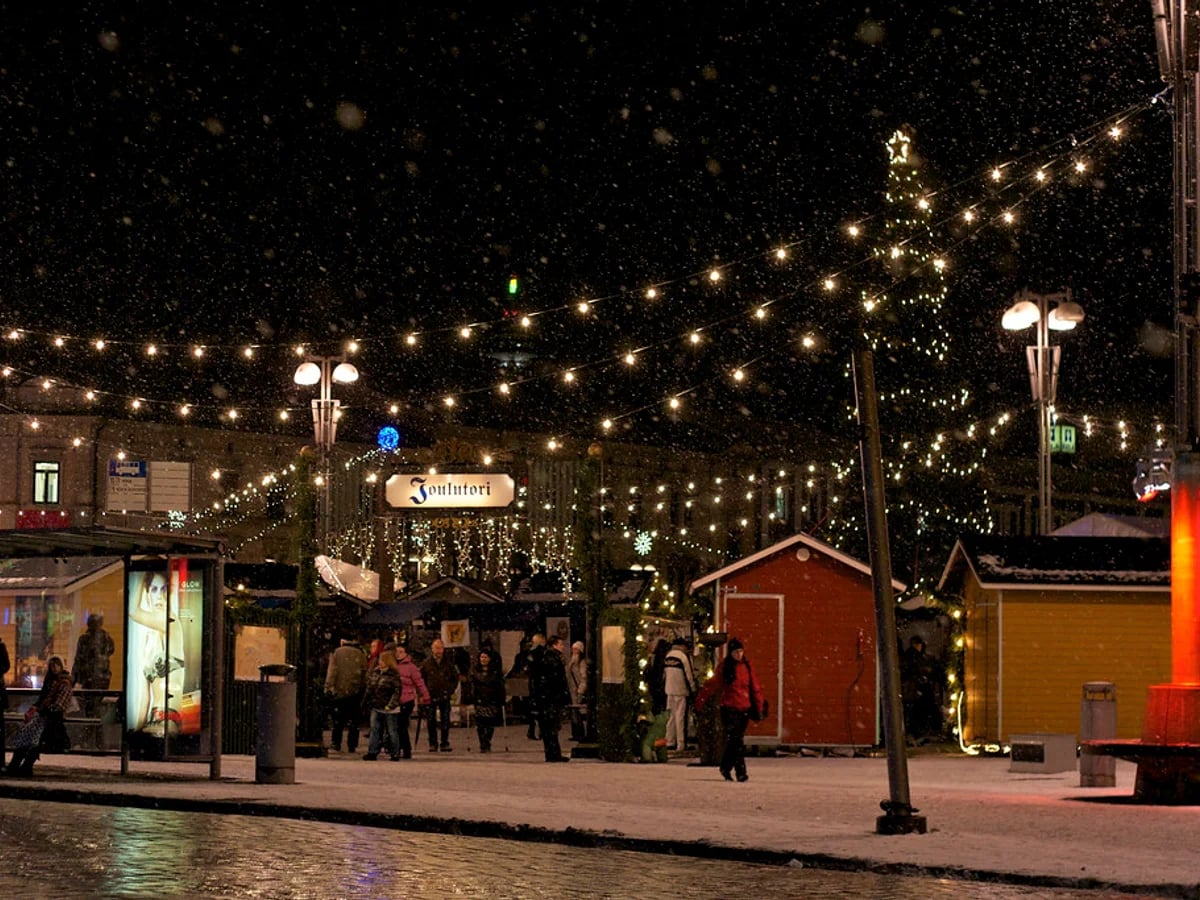 Joulutori market glowing with warm lights in Tampere's Central Square during the enchanting blue hour