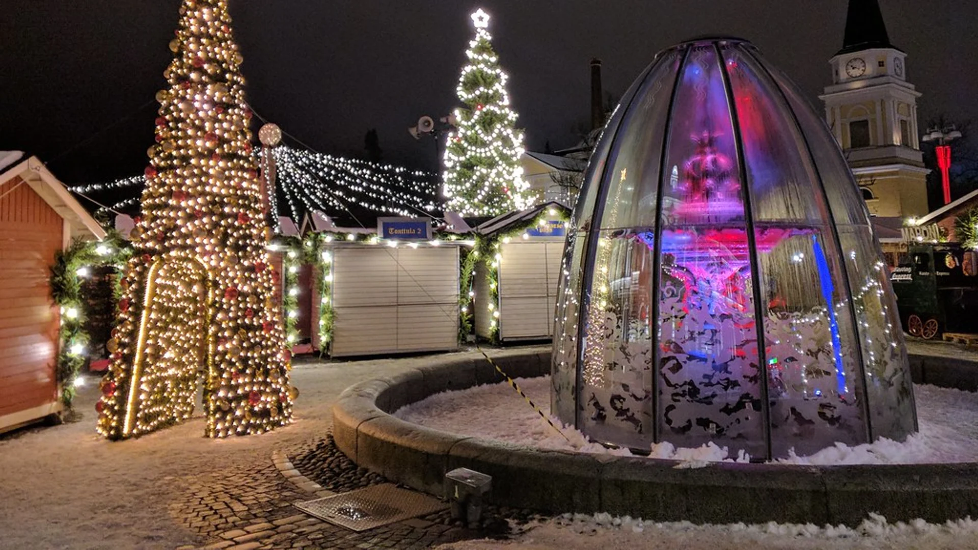 Joulutori's festive illumination at blue hour in Tampere, showcasing Central Square's cathedral backdrop.