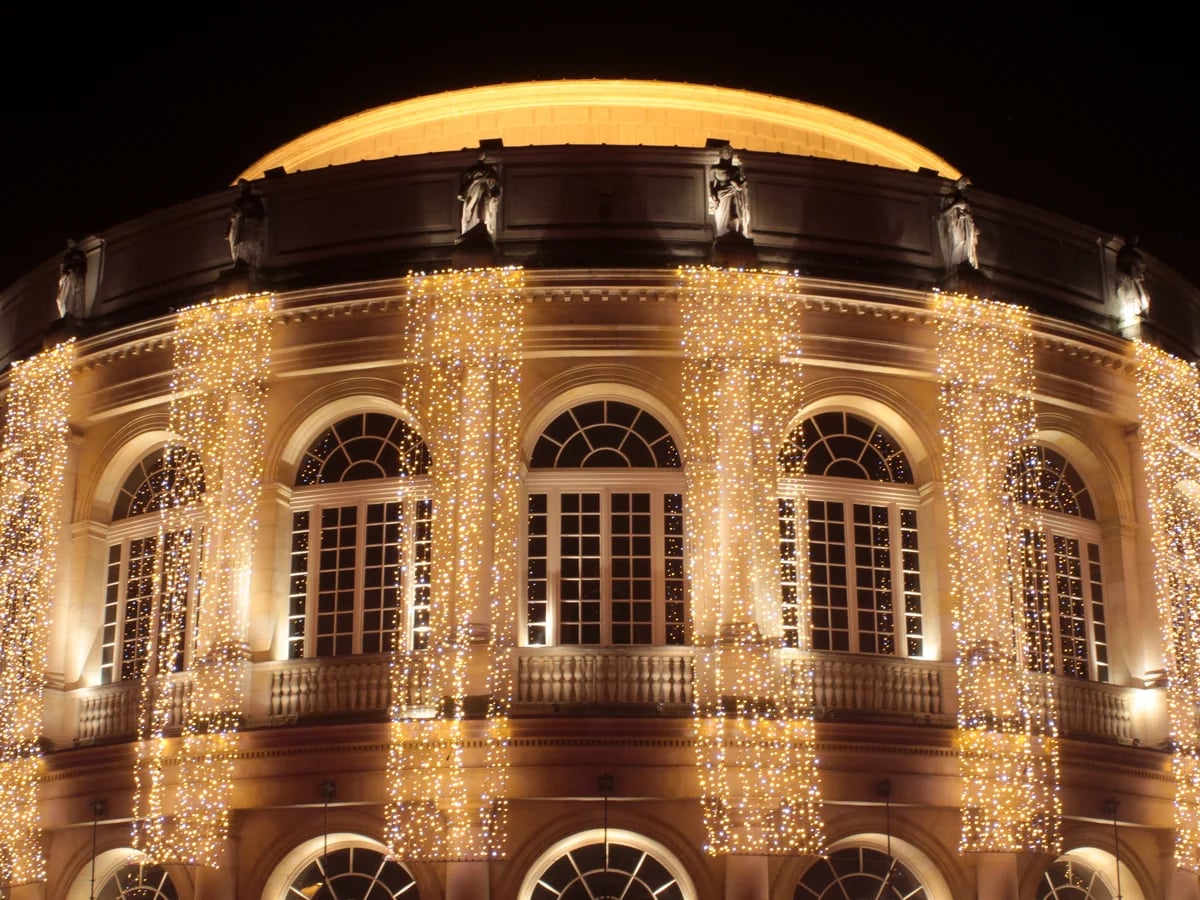 Rennes Opera House adorned with golden Christmas lights in winter night