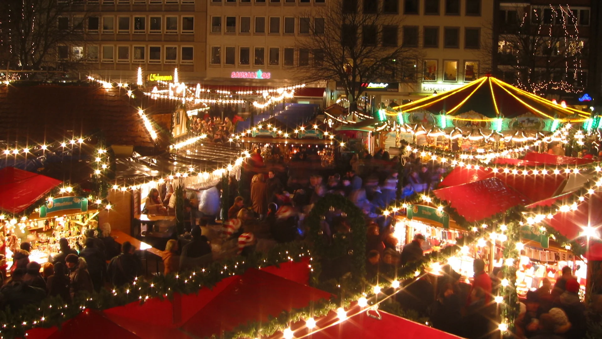 Aachen Christmas market illuminated at night with festive lights and crowds