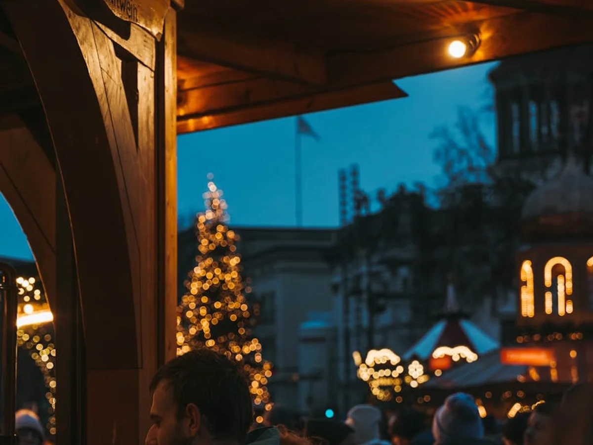 Berlin Christmas market stall with warm lights and bokeh tree in winter