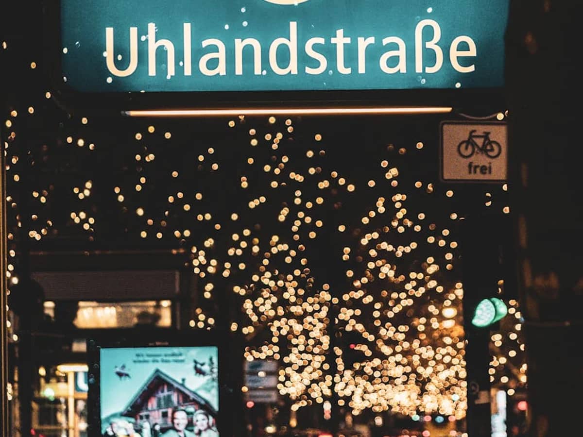 Berlin Uhlandstraße U-Bahn station entrance adorned with golden Christmas lights in winter