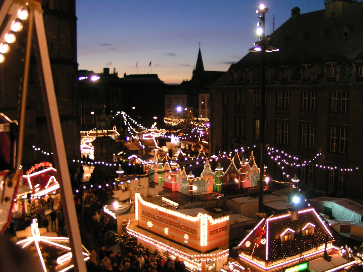 Weihnachtsmarkt Bremen at twilight with illuminated Bremer Rathaus and festive stalls