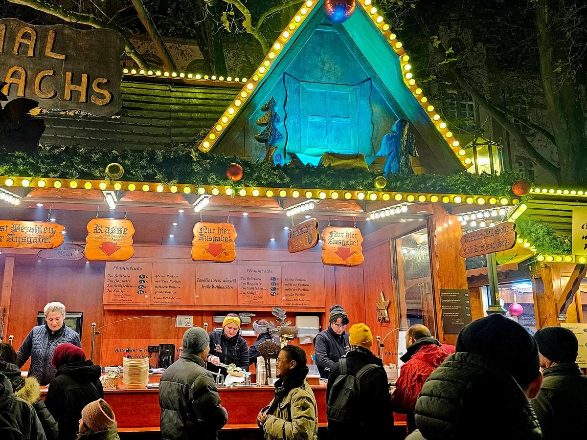 Cologne bustling Christmas market stall with warm festive lights