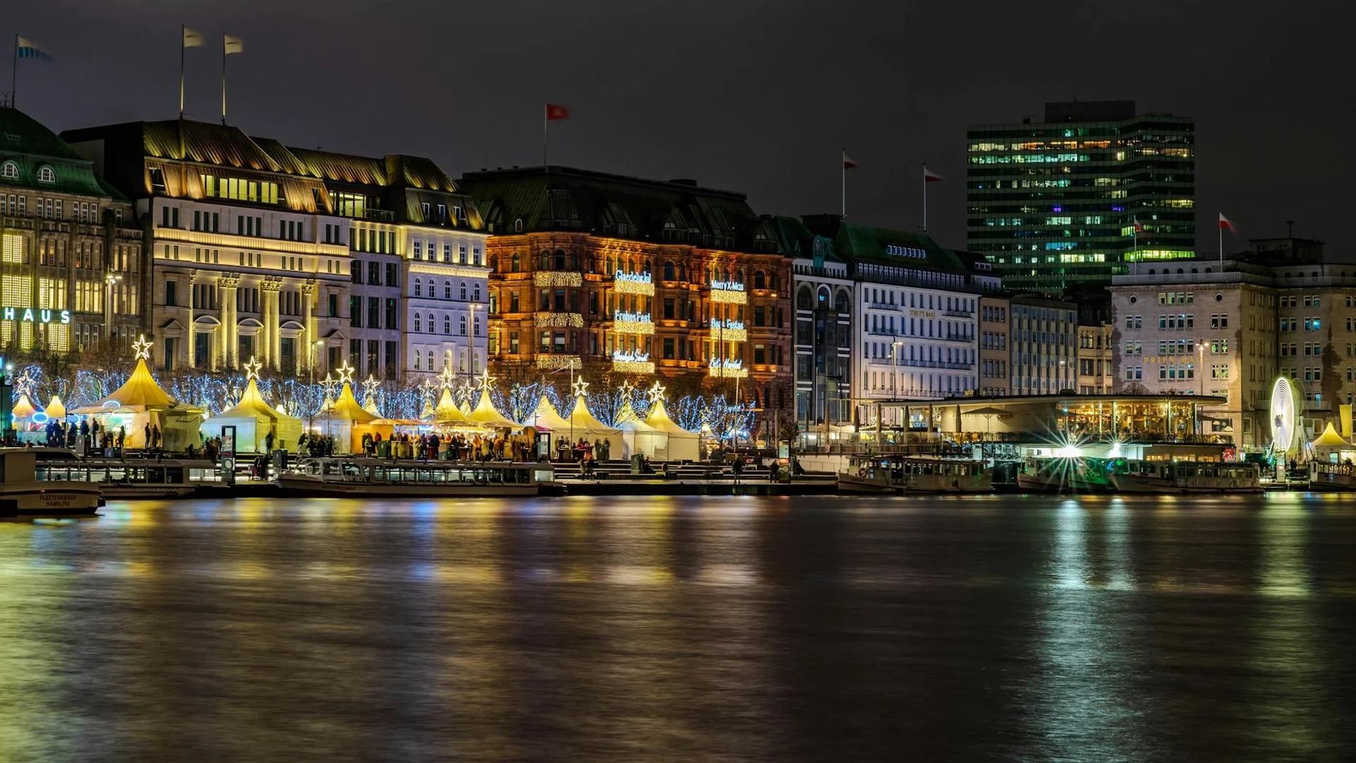 Hamburg Binnenalster waterfront illuminated by festive Christmas lights at twilight