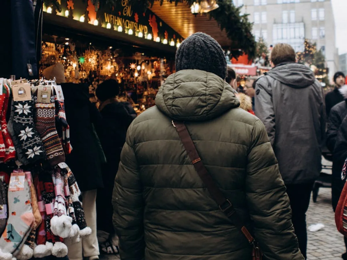 Hannover visitor exploring Christmas market stalls in warm winter lighting