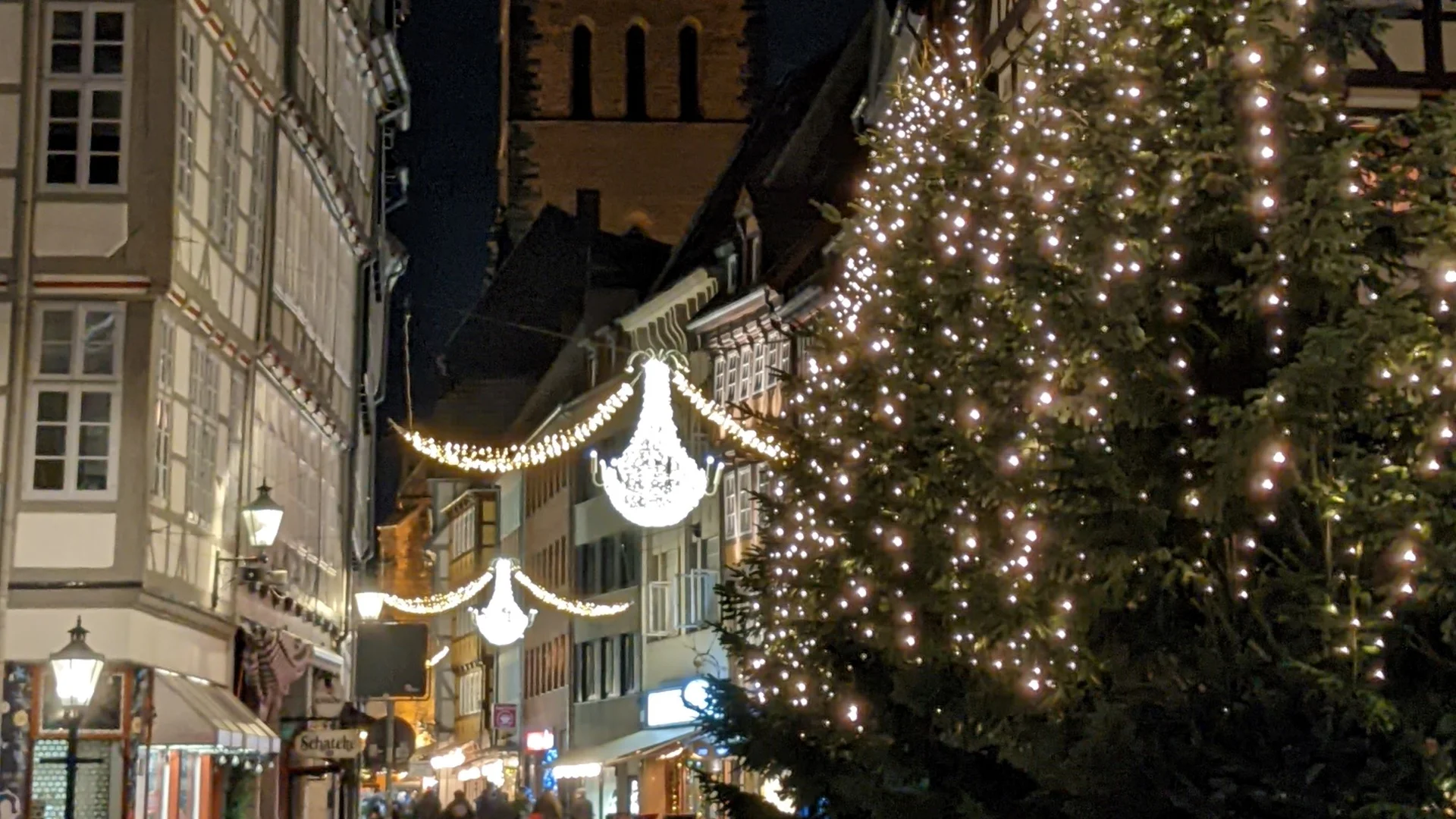 Weihnachtsmarkt Hannover - Marktkirche illuminated at dusk with festive crowds and trees