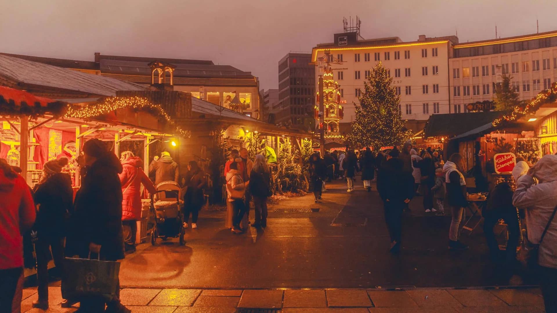 Kassel Christmas market bustling with visitors in warm twilight glow
