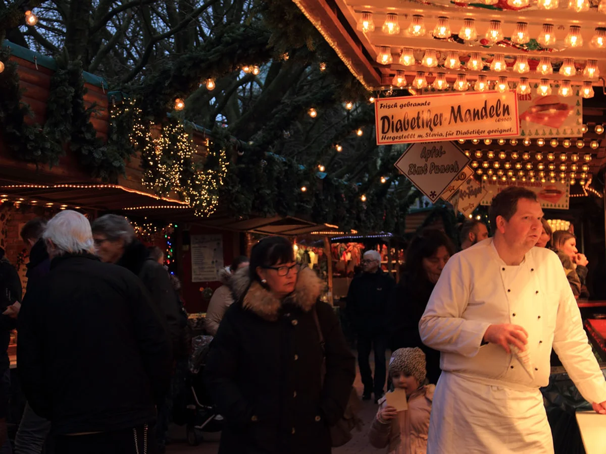 Kieler Weihnachtsmarkt - Holstenplatz visitors enjoying warm golden hour lights in Kiel's festive atmosphere