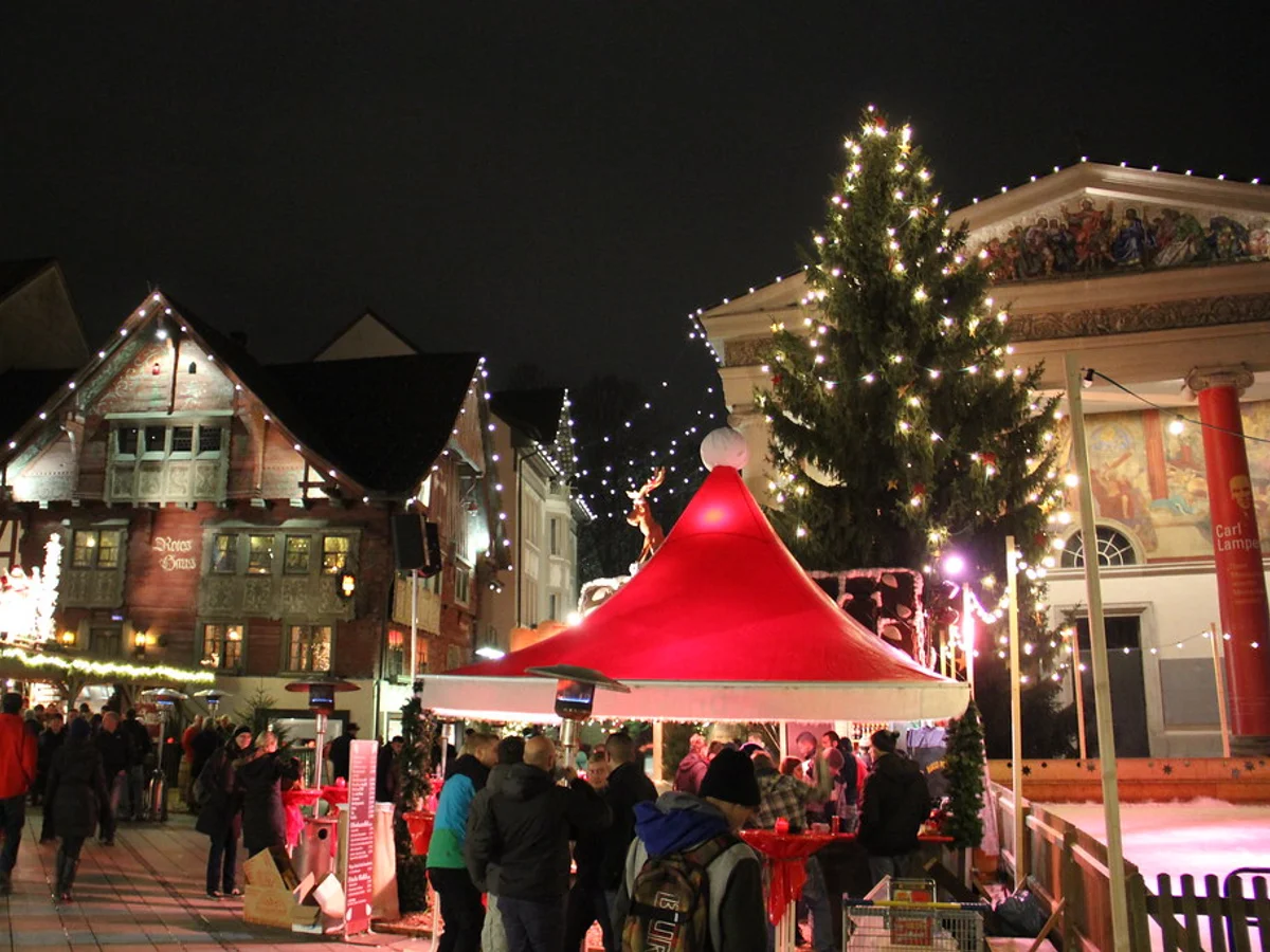 Ludwigsburger Barock-Weihnachtsmarkt illuminated at twilight in Ludwigsburg with Martinskirche steeple.
