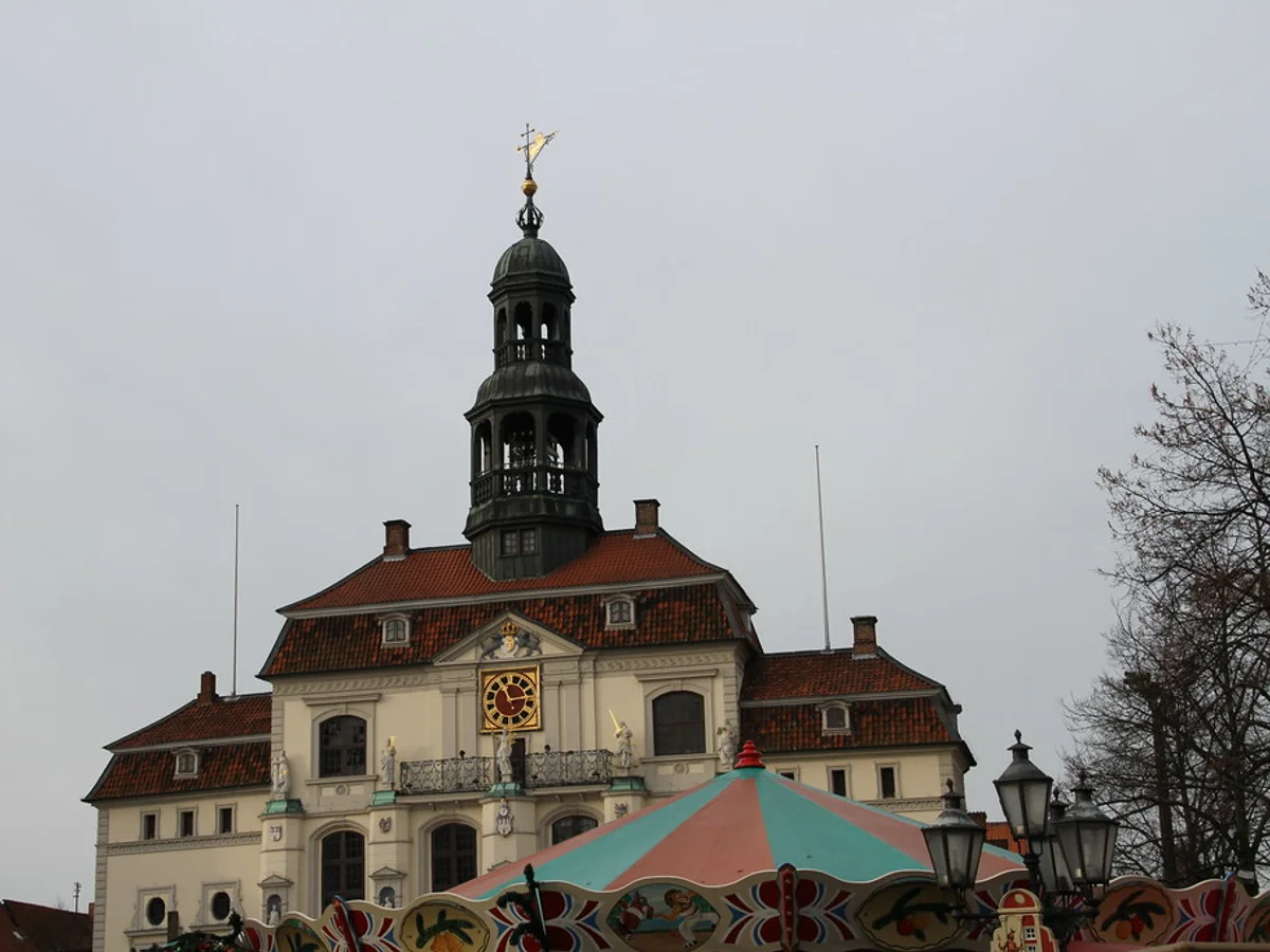 TO HUUS Weihnachtsmarkt festive stalls in Lüneburg with iconic Renaissance Town Hall backdrop