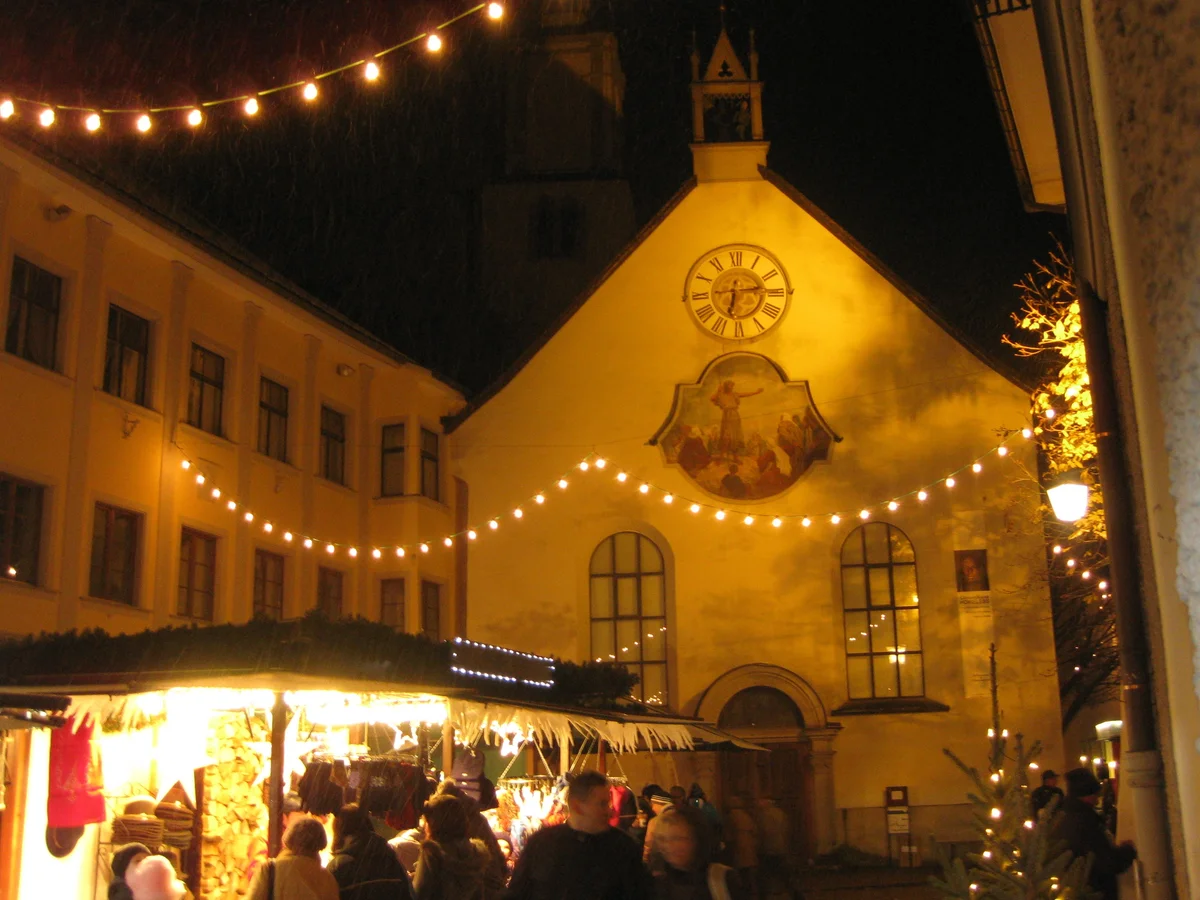 Romantischer Weihnachtsmarkt Nördlingen with St. George's Church spire glowing during twilight in Nordlingen