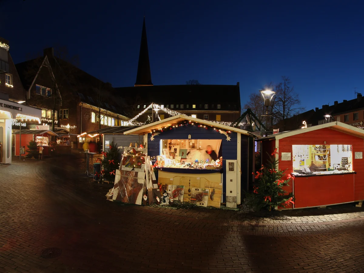 Romantischer Weihnachtsmarkt Nördlingen glows warmly in twilight with St. George's Church spire in the background.