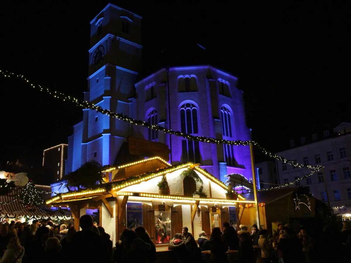 Christkindlmarkt - Neupfarrplatz illuminated stalls Regensburg festive atmosphere Neupfarrkirche tower