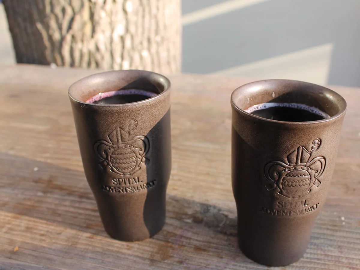 Ventsmarkt mulled wine in Regensburg's Spitalgarten, warm festive atmosphere at historic market