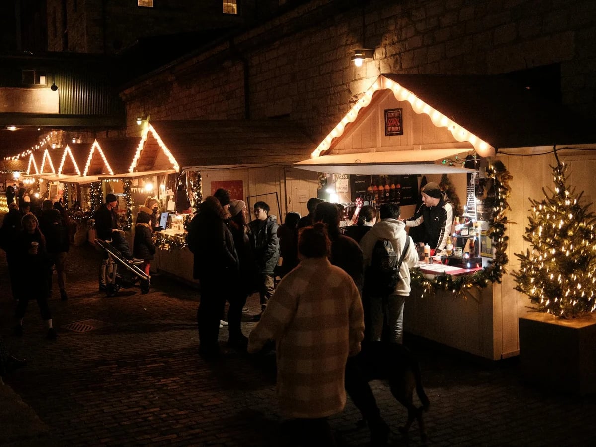 Cork bustling Christmas market scene with festive crowds and wooden chalets