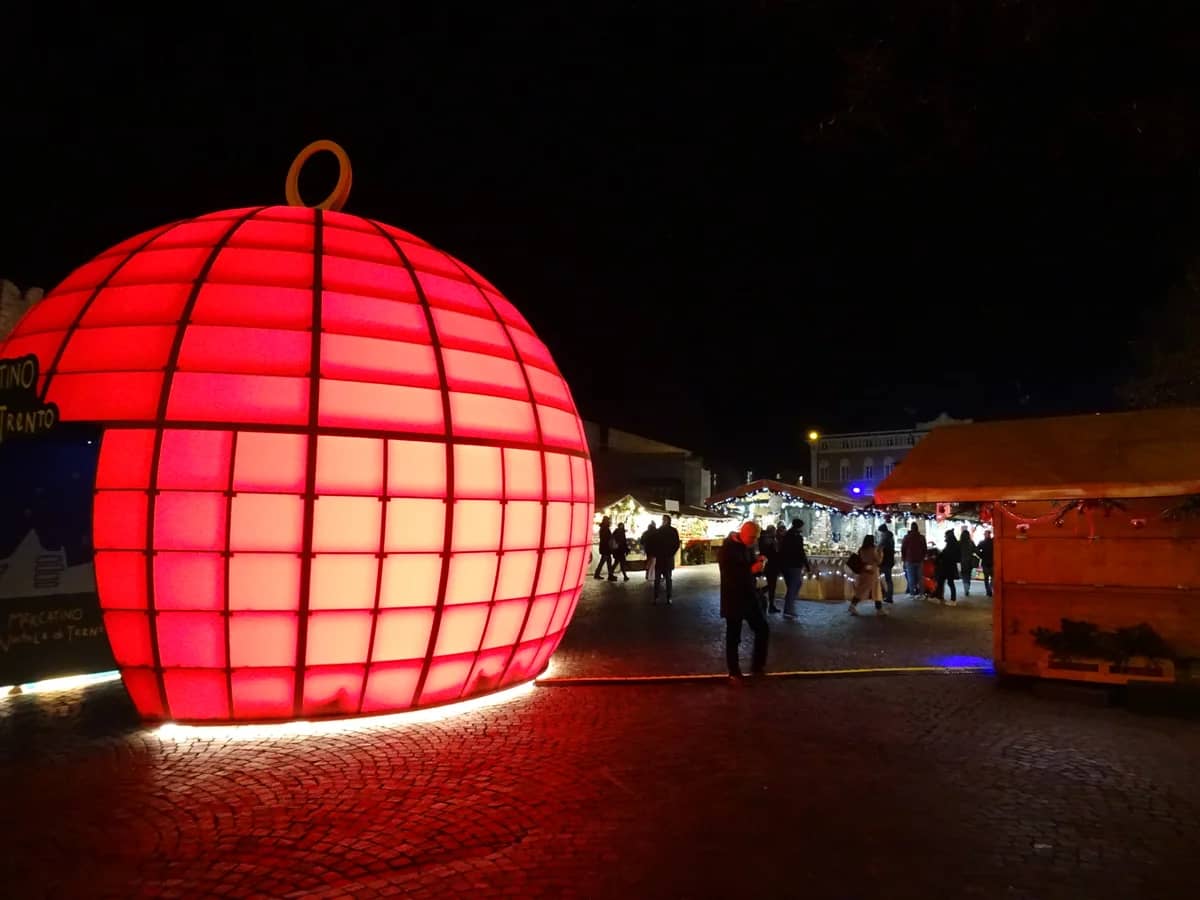 Trento glowing red ornament installation in a festive winter market