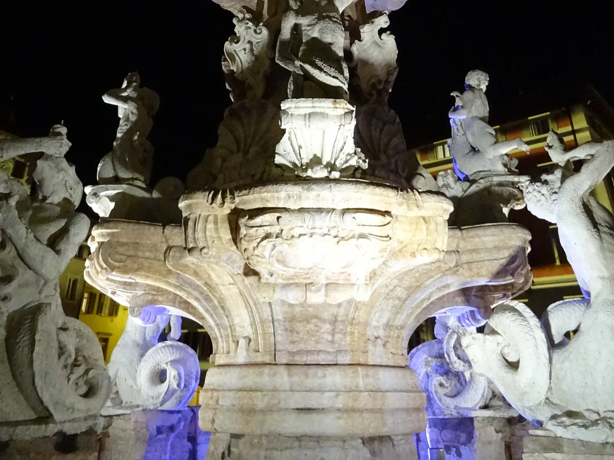 Trento Neptune Fountain illuminated at night during the Christmas season