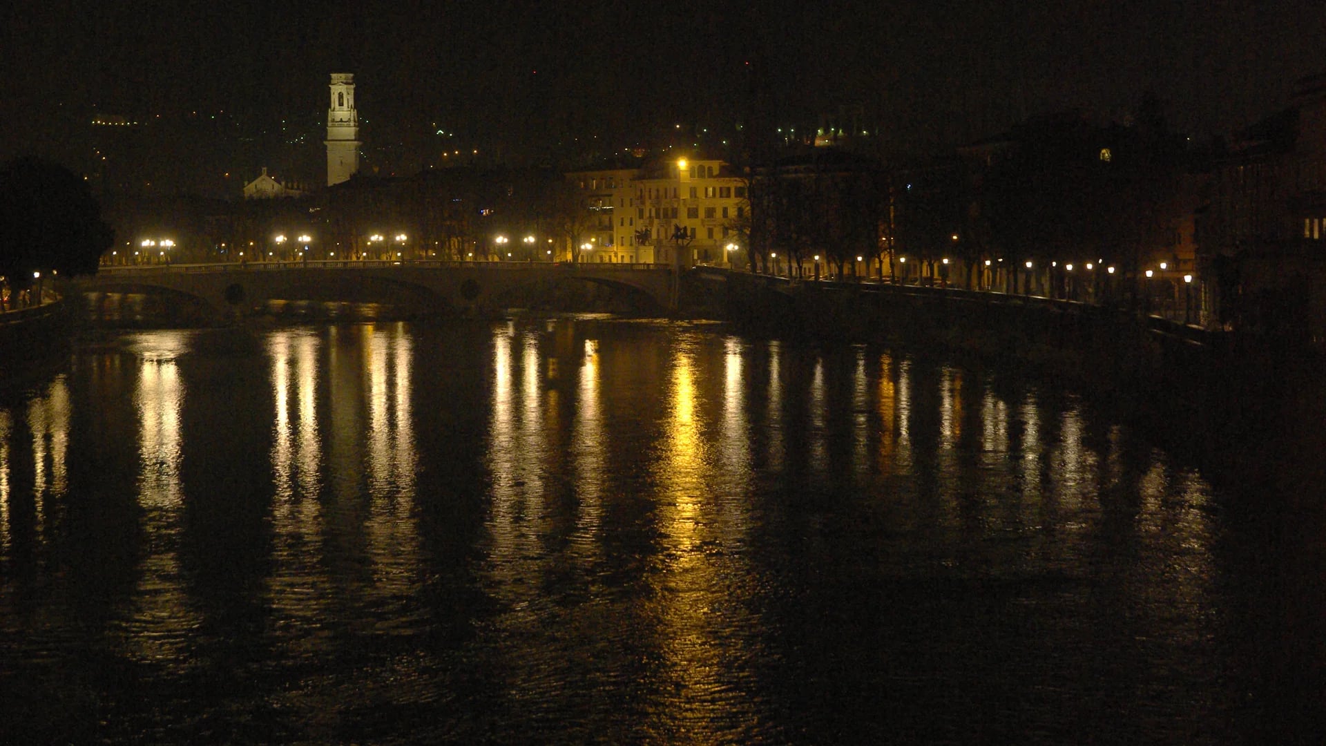 Verona Duomo tower reflected in the Adige River during a magical winter evening