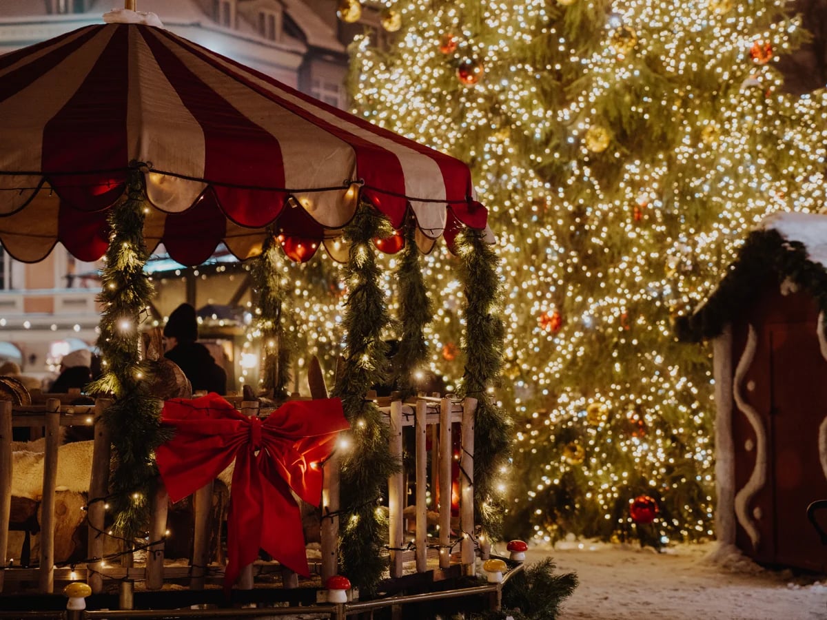 Riga Christmas market stall glowing with festive lights and tree in winter