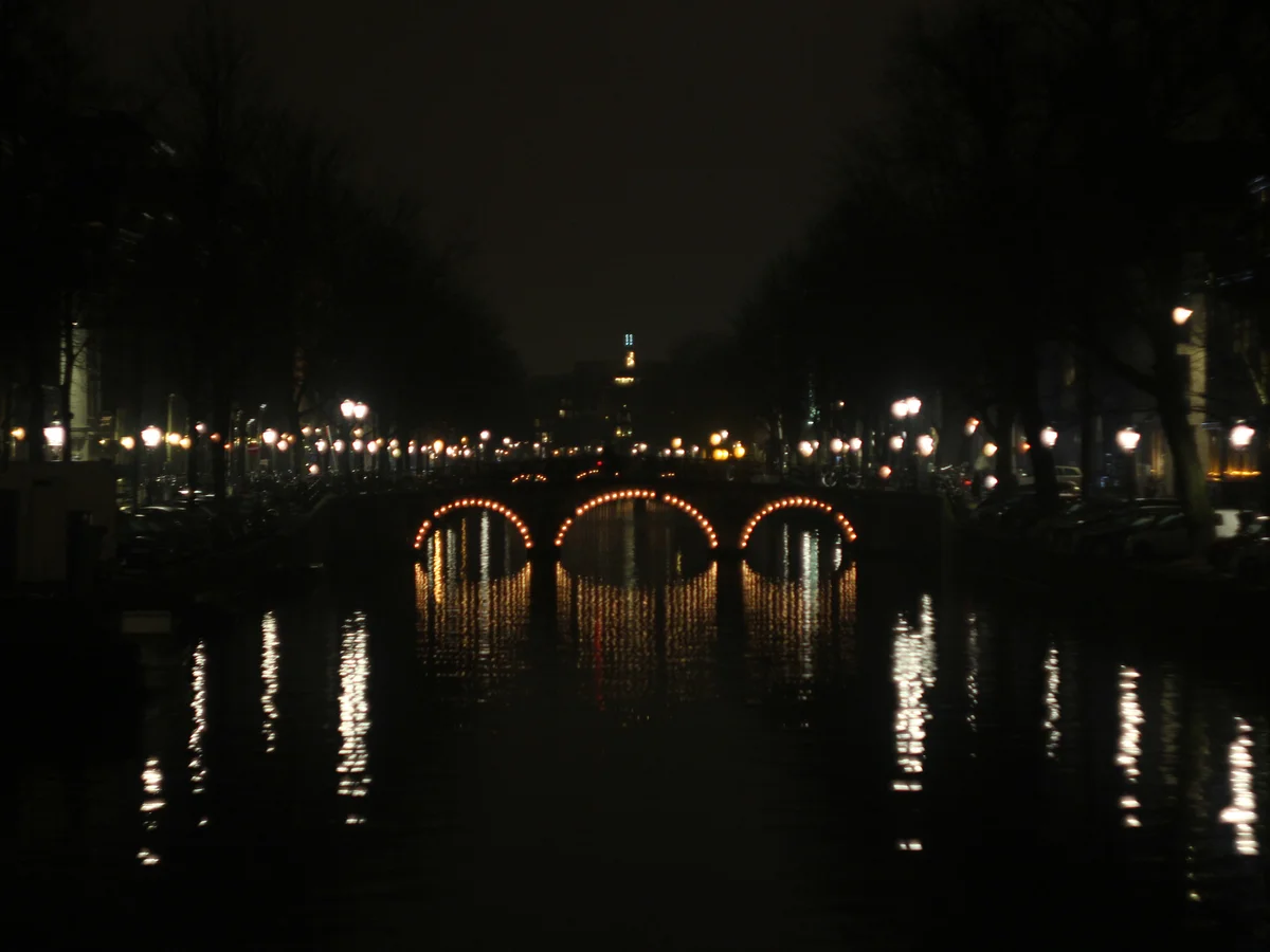 Amsterdam illuminated canal bridge in winter evening atmosphere