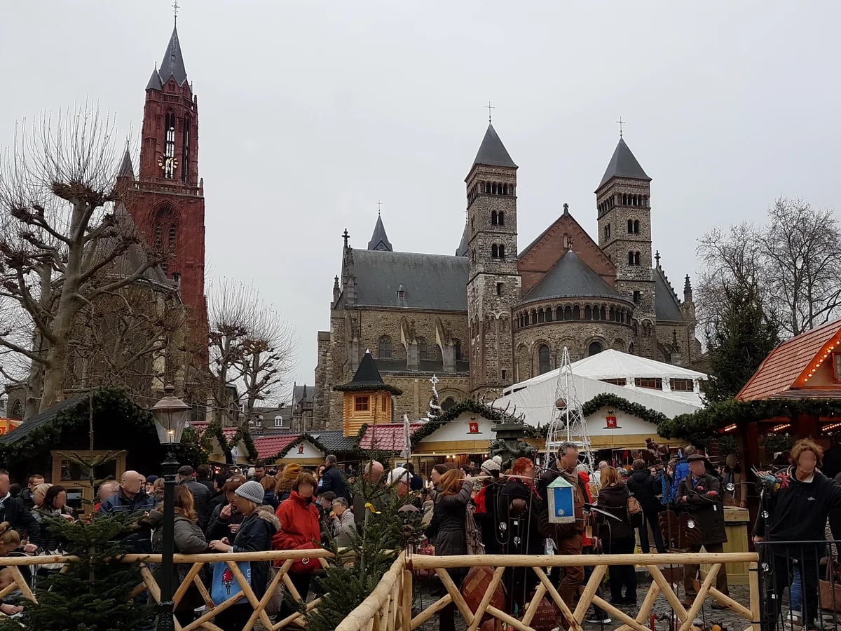 Maastricht bustling Christmas market with iconic twin spires in winter