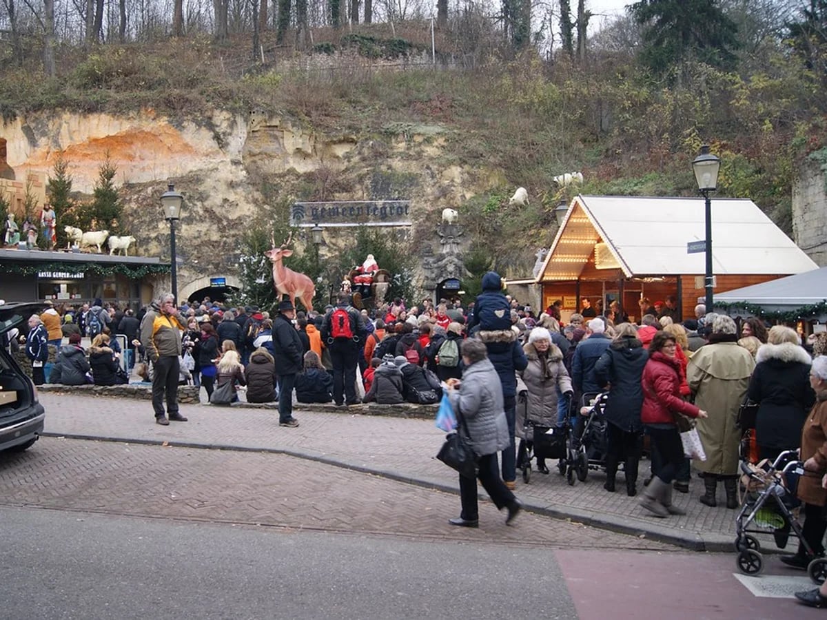 Kerststad Valkenburg underground market at Wilhelminagroeve showcasing crowds and festive stalls.