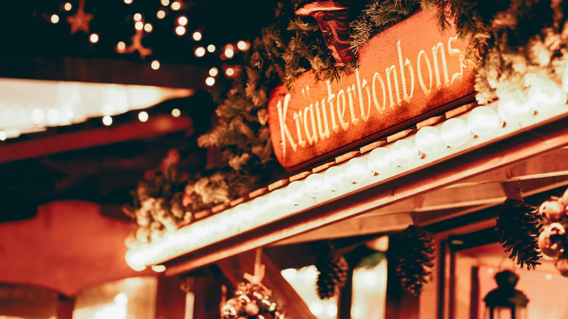 Valkenburg market stall adorned with evergreen garland, festive glow