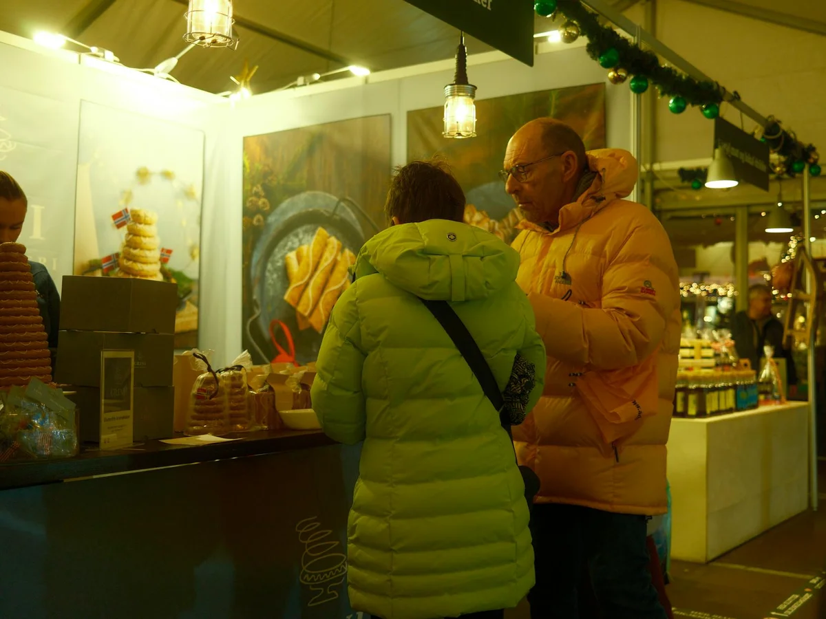 Bergen warm Christmas market scene with visitors enjoying Norwegian treats