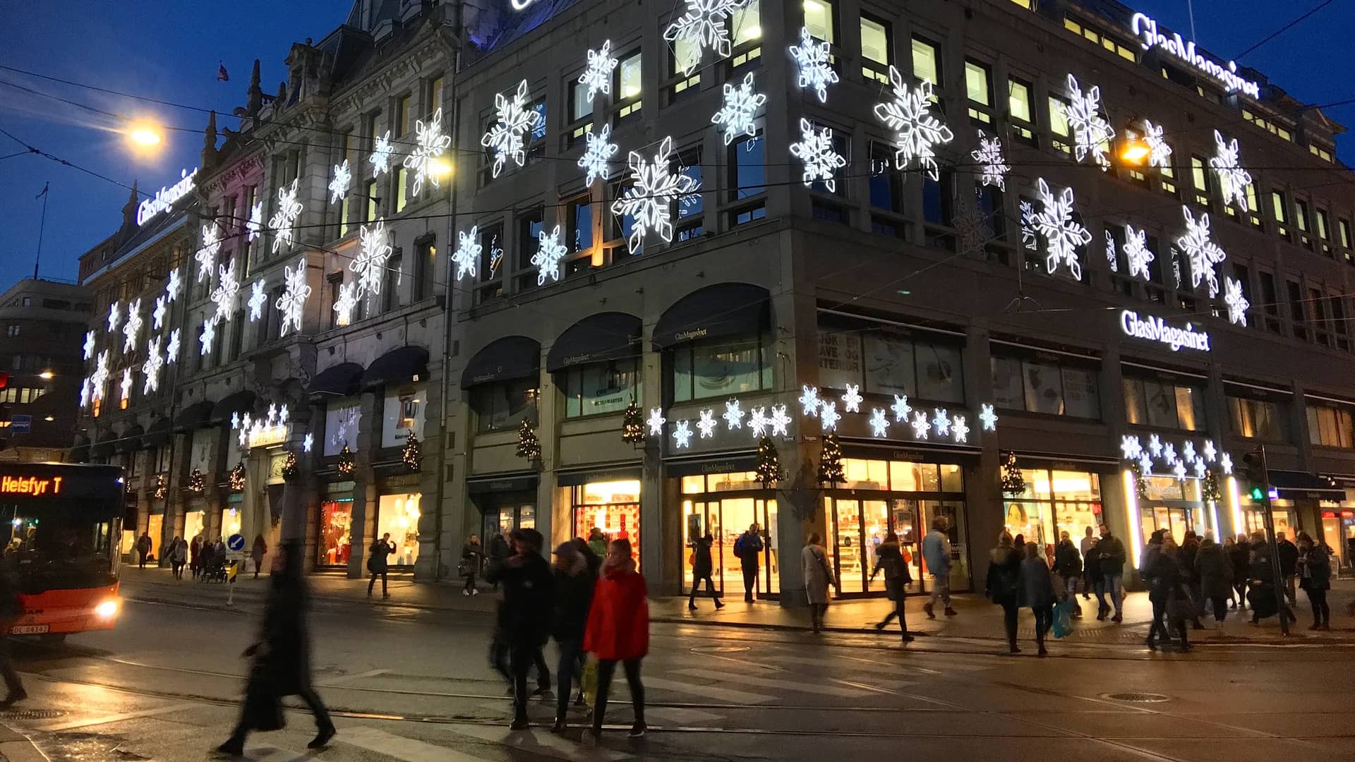 Oslo's GlasMagasinet adorned with festive snowflakes during winter evening