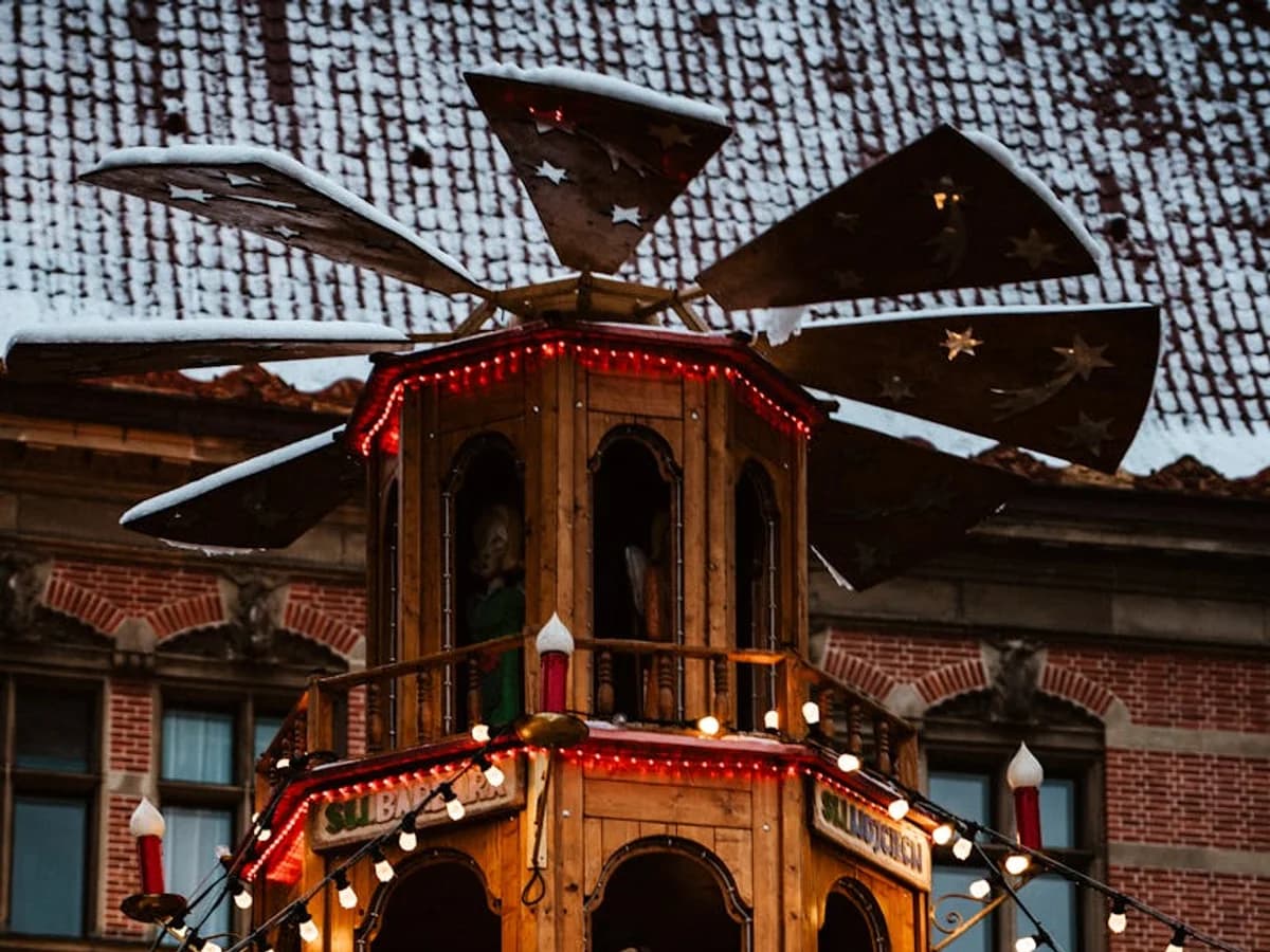 Gdansk traditional wooden Christmas pyramid tower adorned with festive red lights and garland